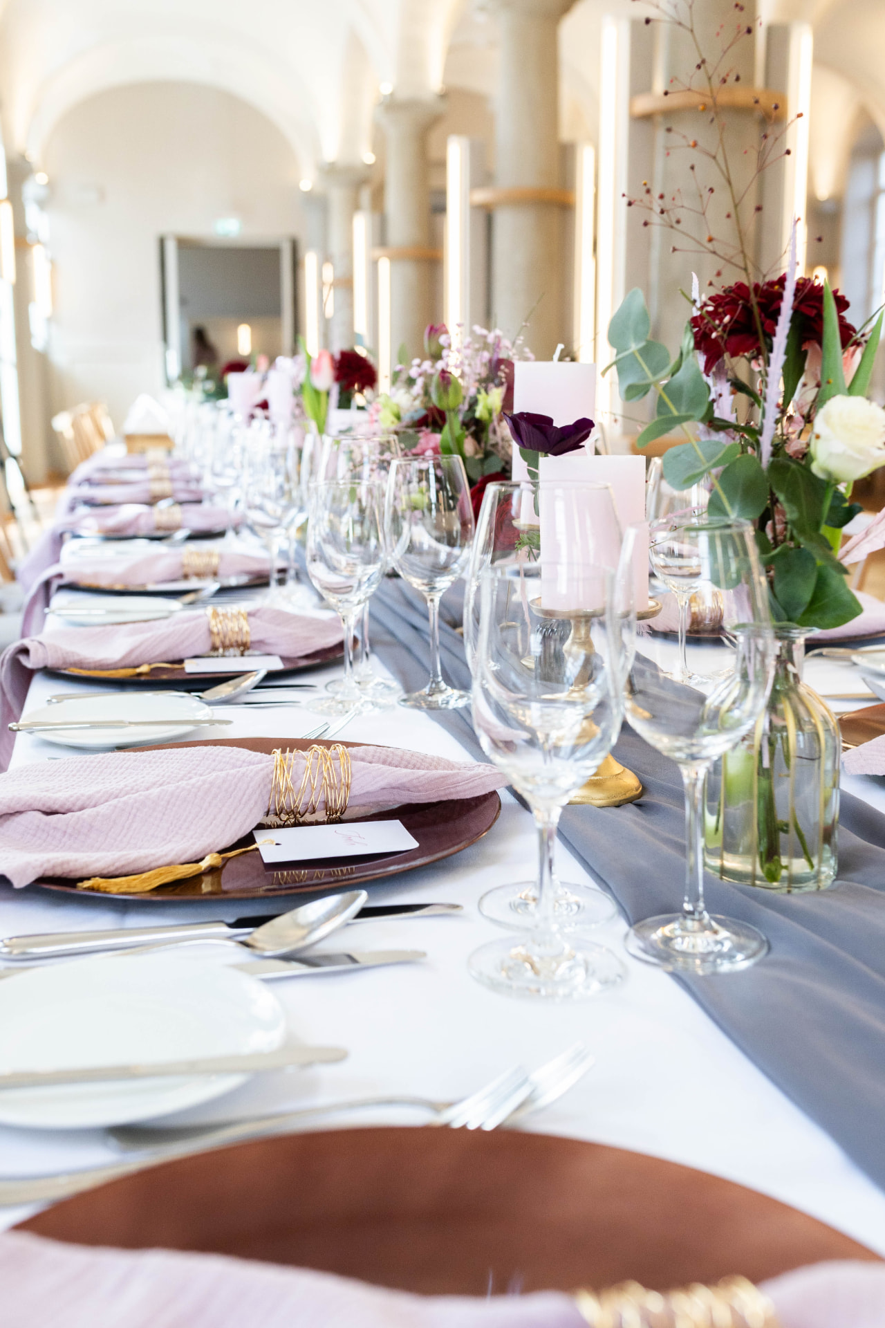 Festlich gedeckte Tafel mit rosafarbenen Servietten und Blumenschmuck